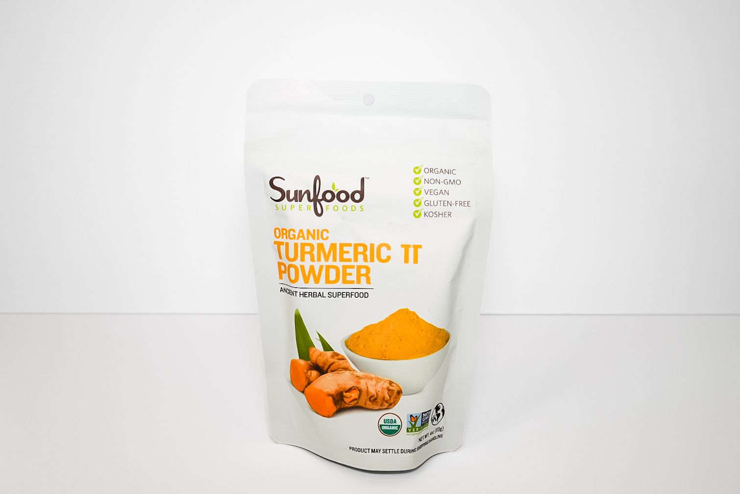 Sunfood Organic Turmeric Powder pouch with turmeric roots and yellow powder on white background