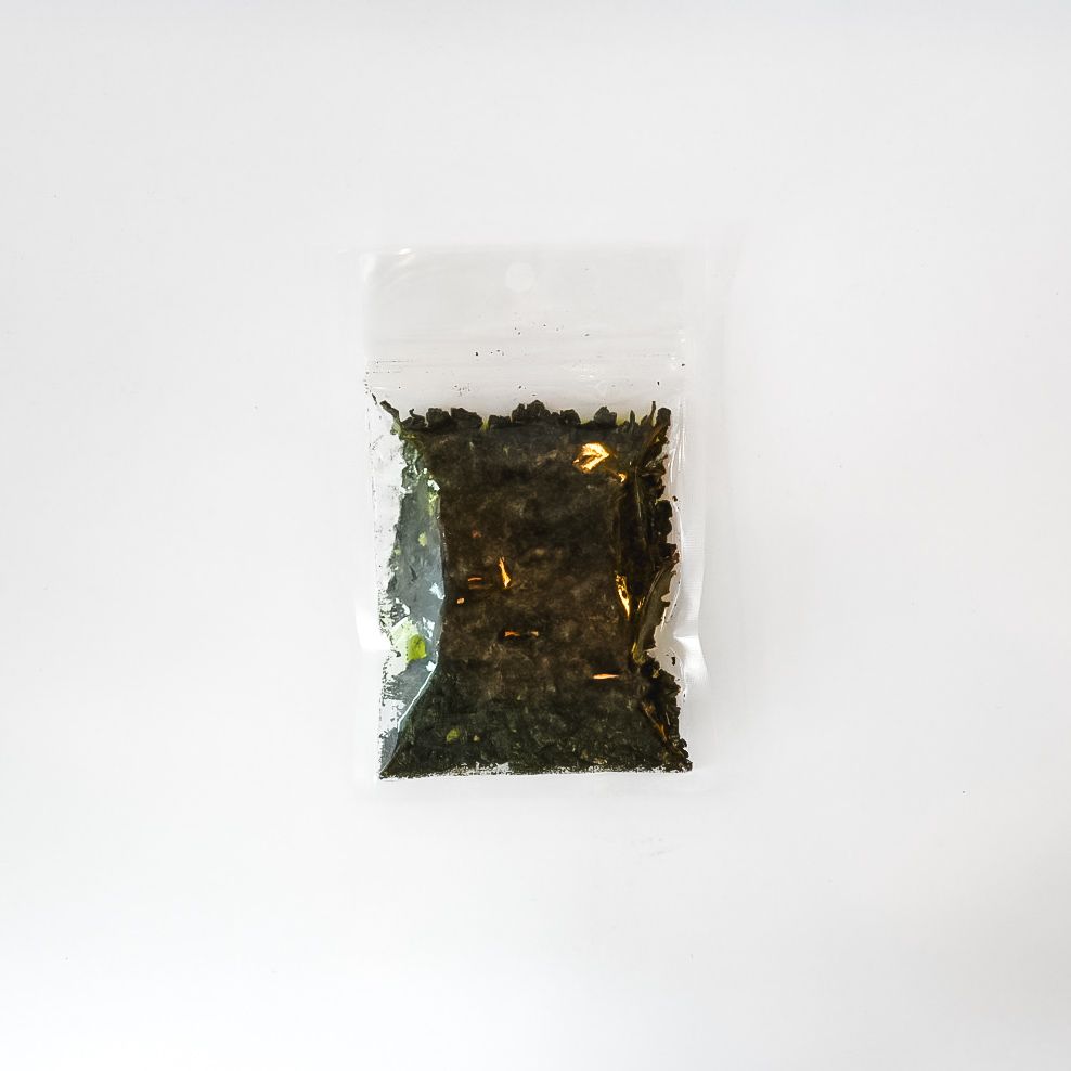 Clear plastic bag of Oolong tea with bright yellow label and loose tea leaves inside
