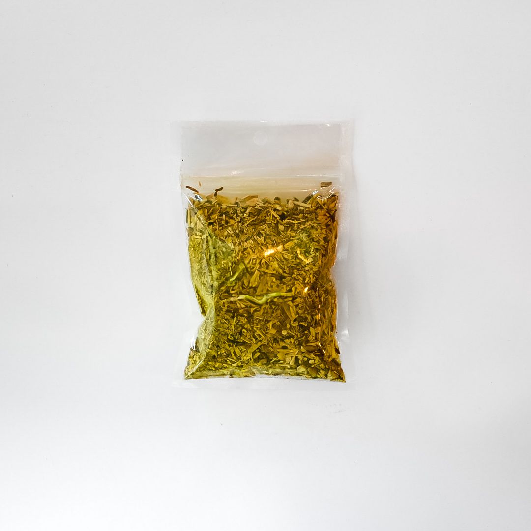 Small clear bag of dried herbs with a bright yellow label on a white background