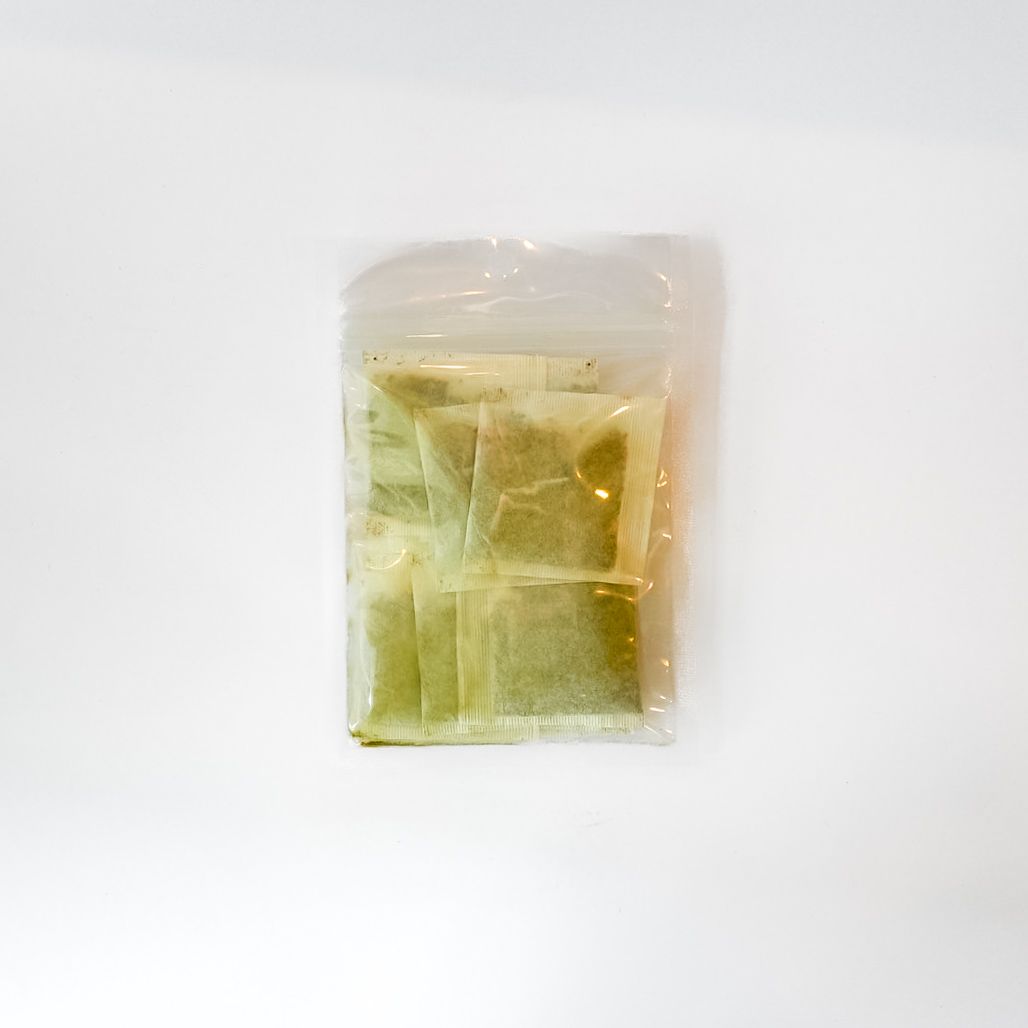Clear plastic bag with a bright yellow label containing a small packaged item on a white background