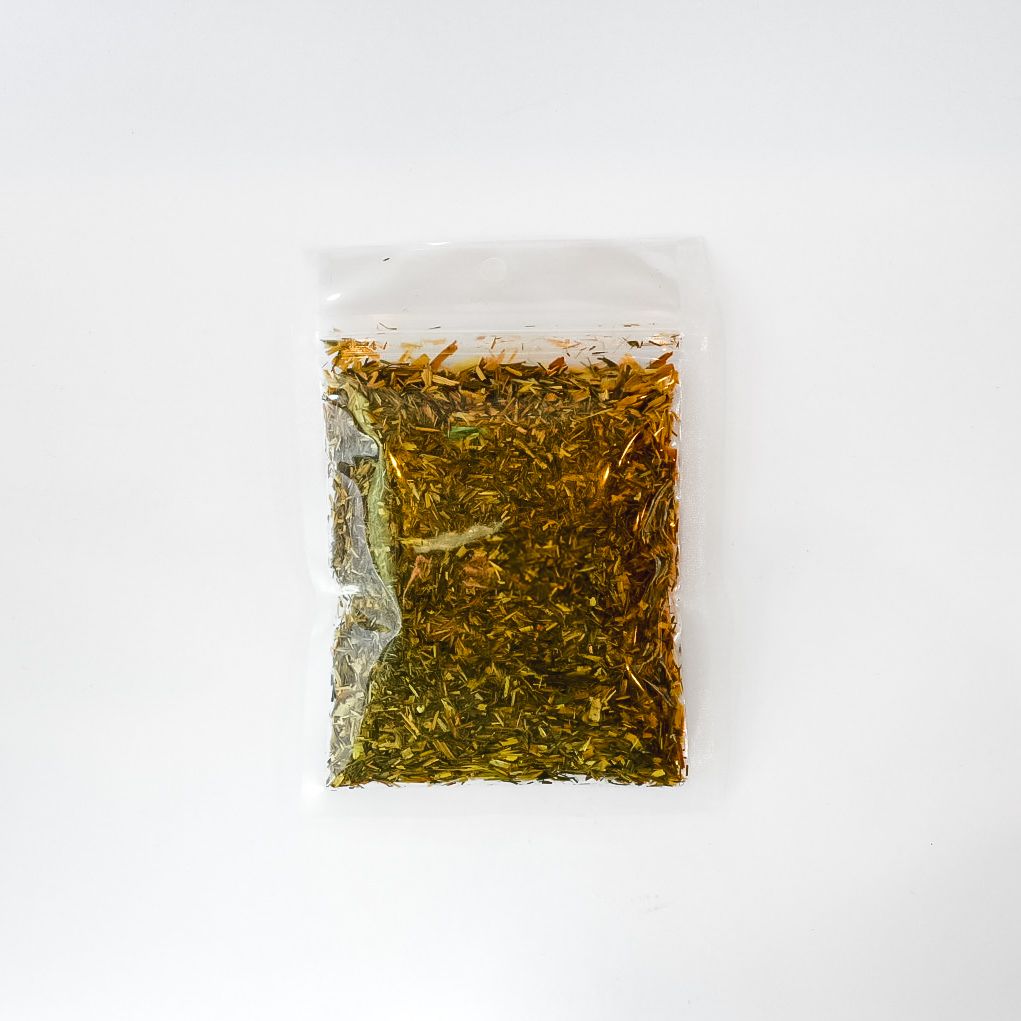 Clear plastic bag of dried herbs with a bright yellow label on a white background
