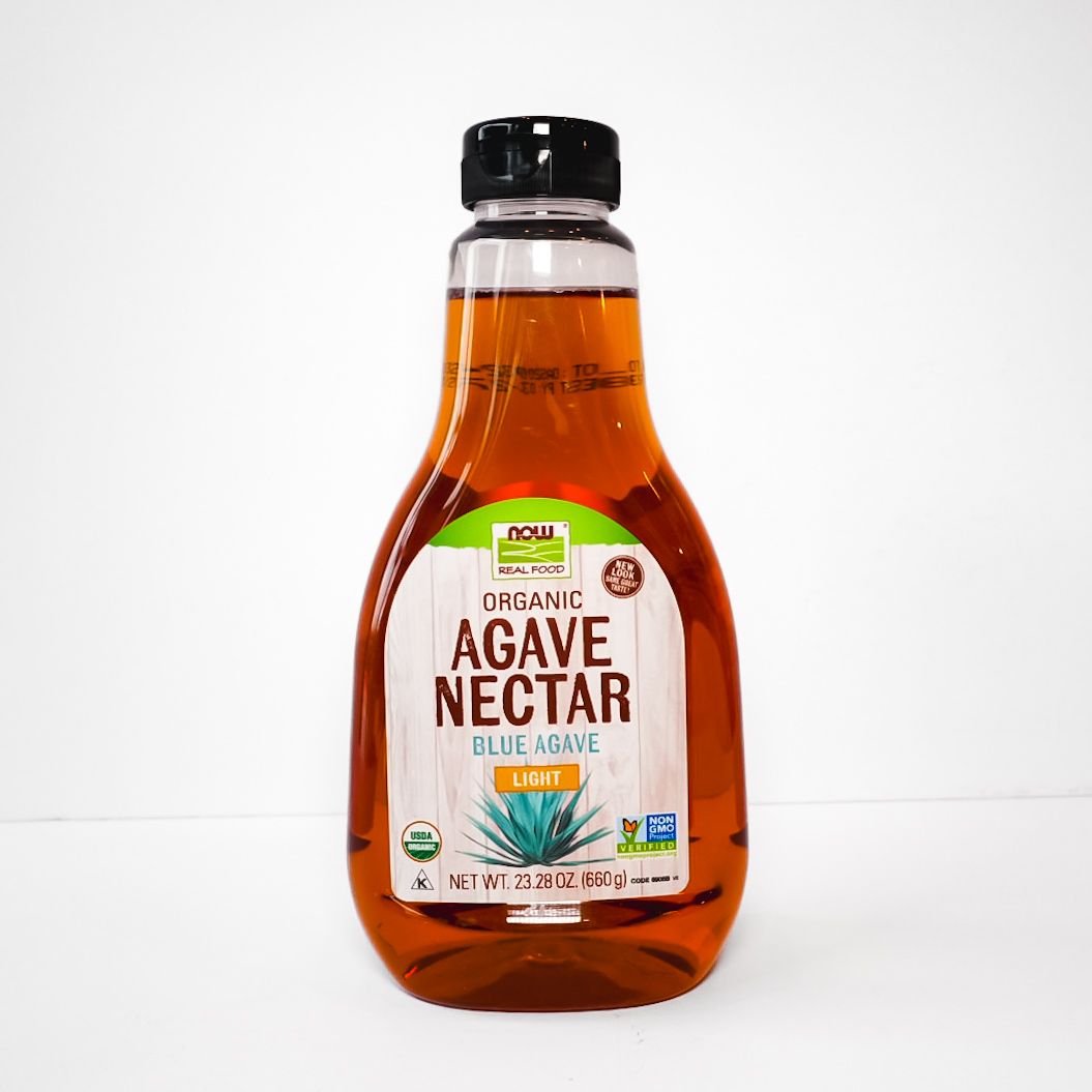 Bottle of organic agave nectar with amber liquid and white label on a white background