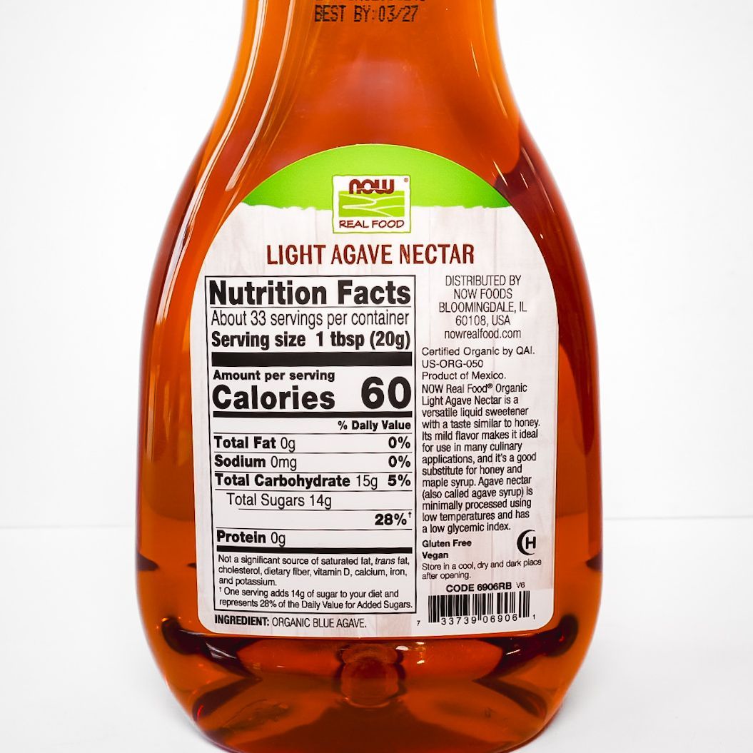 Bottle of organic agave nectar with amber liquid and black cap on a white background