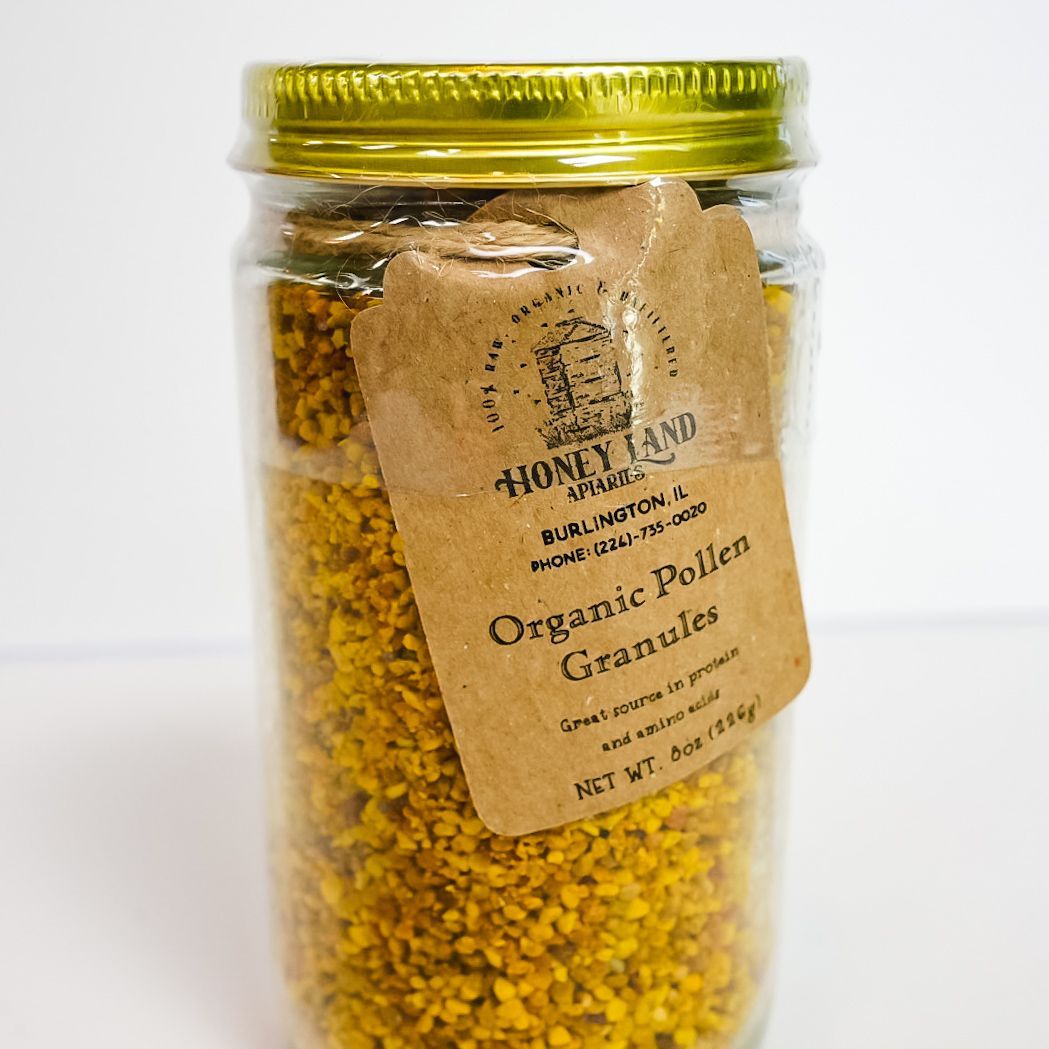 Glass jar of yellow granules with a gold lid and a hanging label on a white background