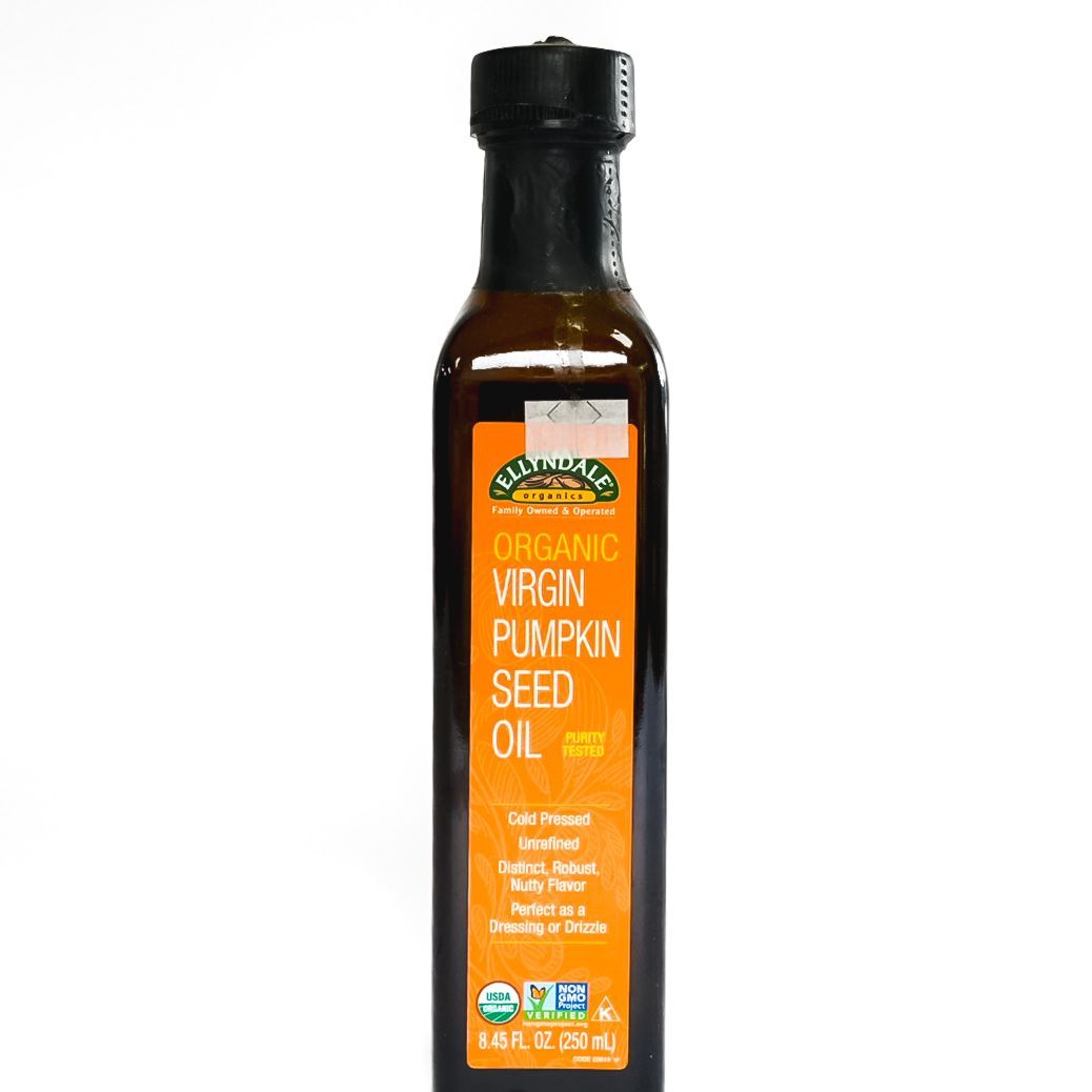 Bottle of organic virgin pumpkin seed oil with orange label on white background