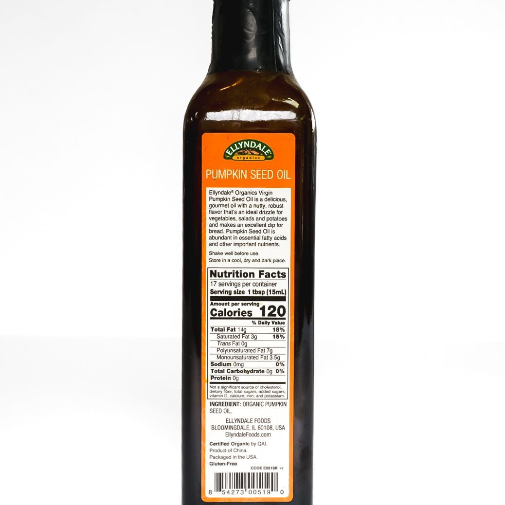 Bottle of organic virgin pumpkin seed oil with orange label on white background