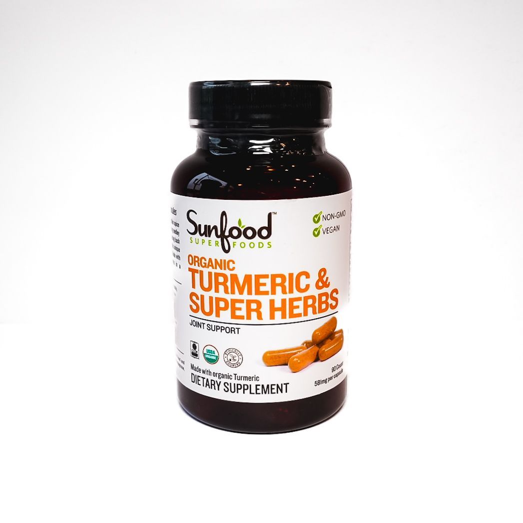 Bottle of Sundhed Organic Turmeric & Super Herbs supplement on white background