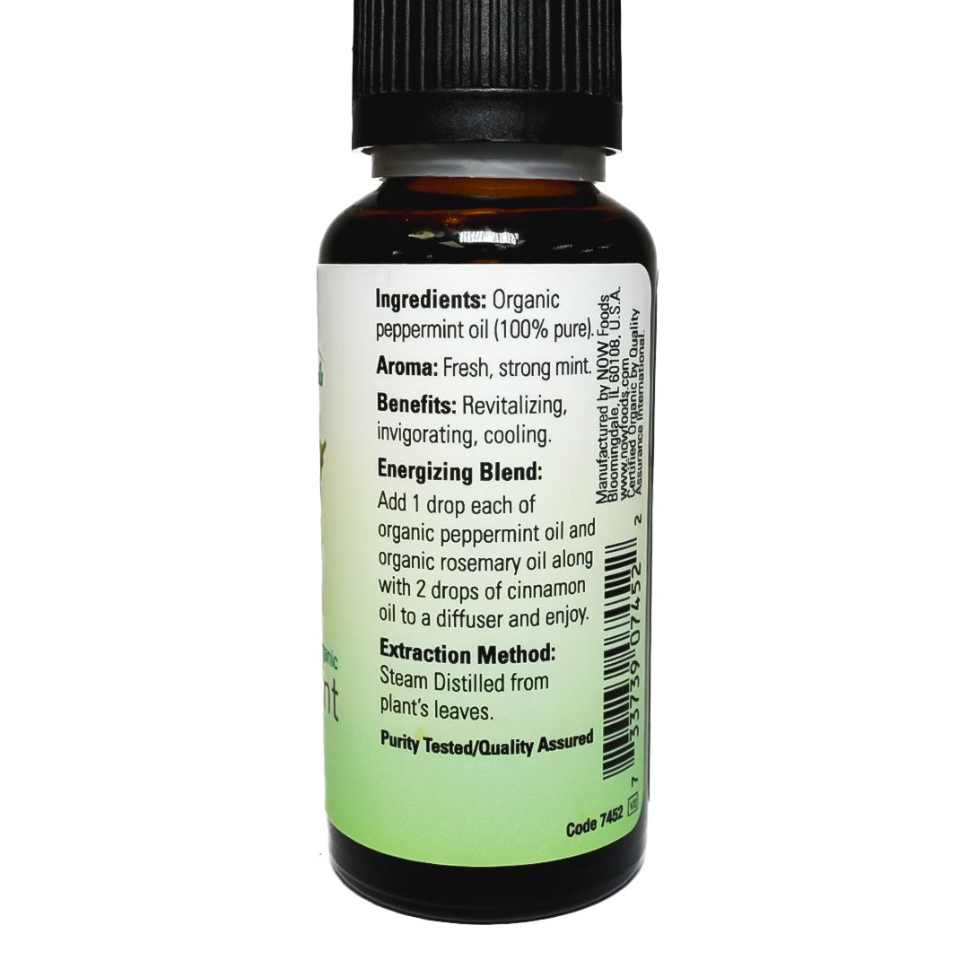 NOW Peppermint essential oil bottle with green peppermint leaves on a white background