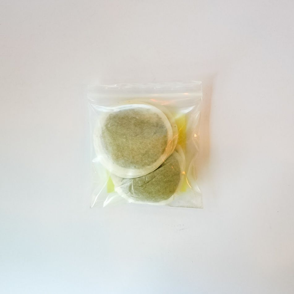 Clear plastic bag of peppermint leaf tea bags with a bright yellow label on a white background