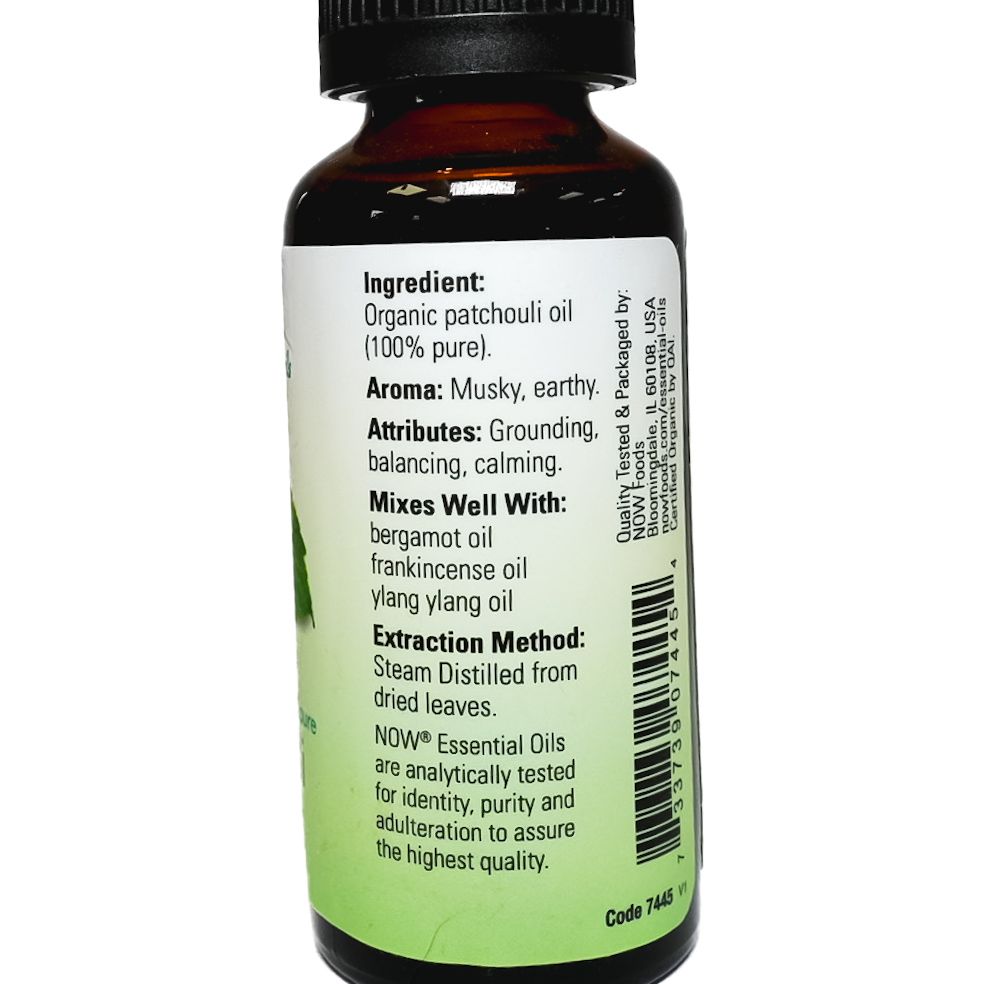 Small bottle of NOW Essential Oils patchouli essential oil with a black cap and green leaf label