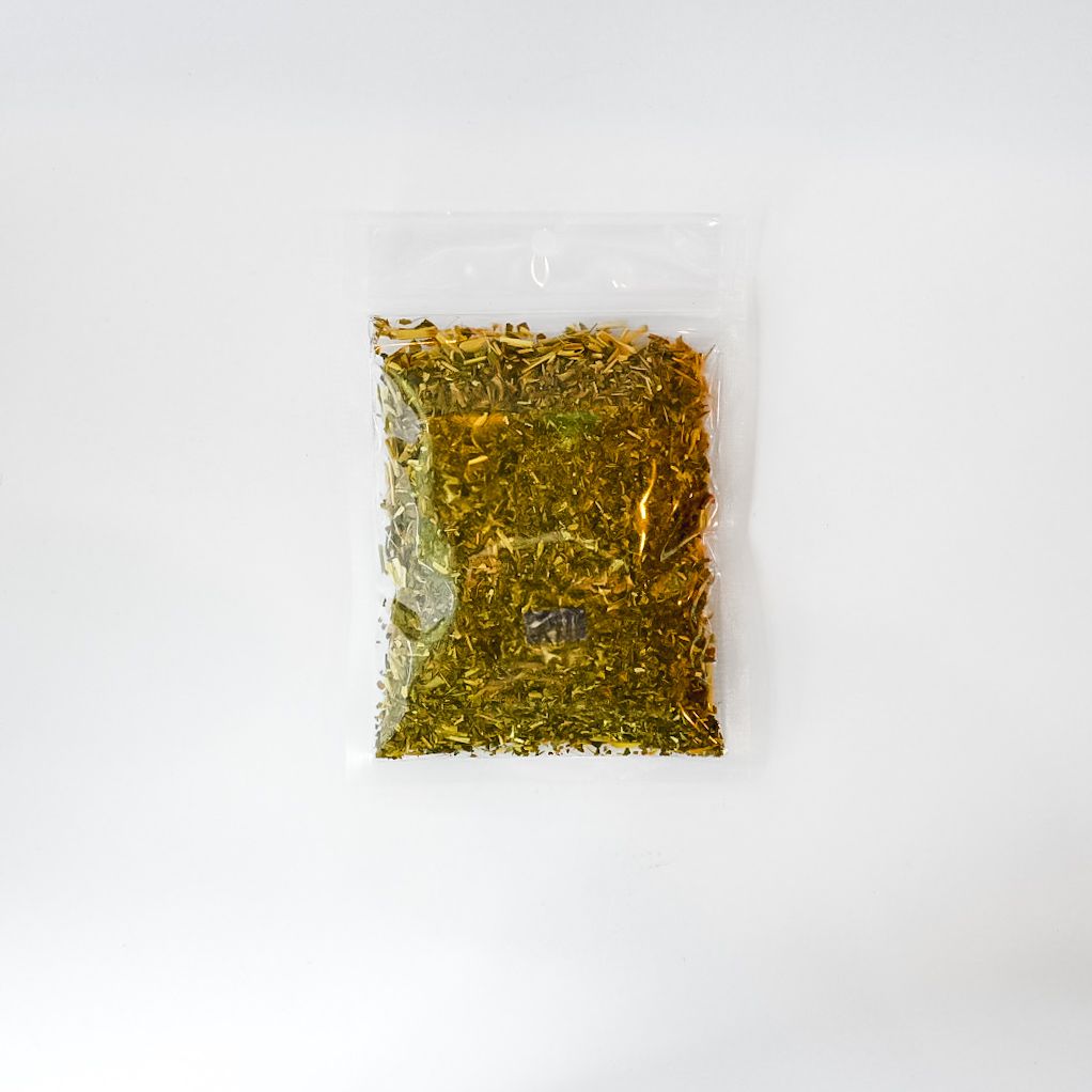 Clear plastic bag of dried herbs with a bright yellow label on a white background