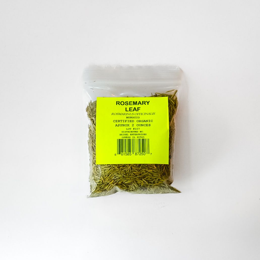 Small clear bag of dried rosemary leaves with a bright yellow label on a white background