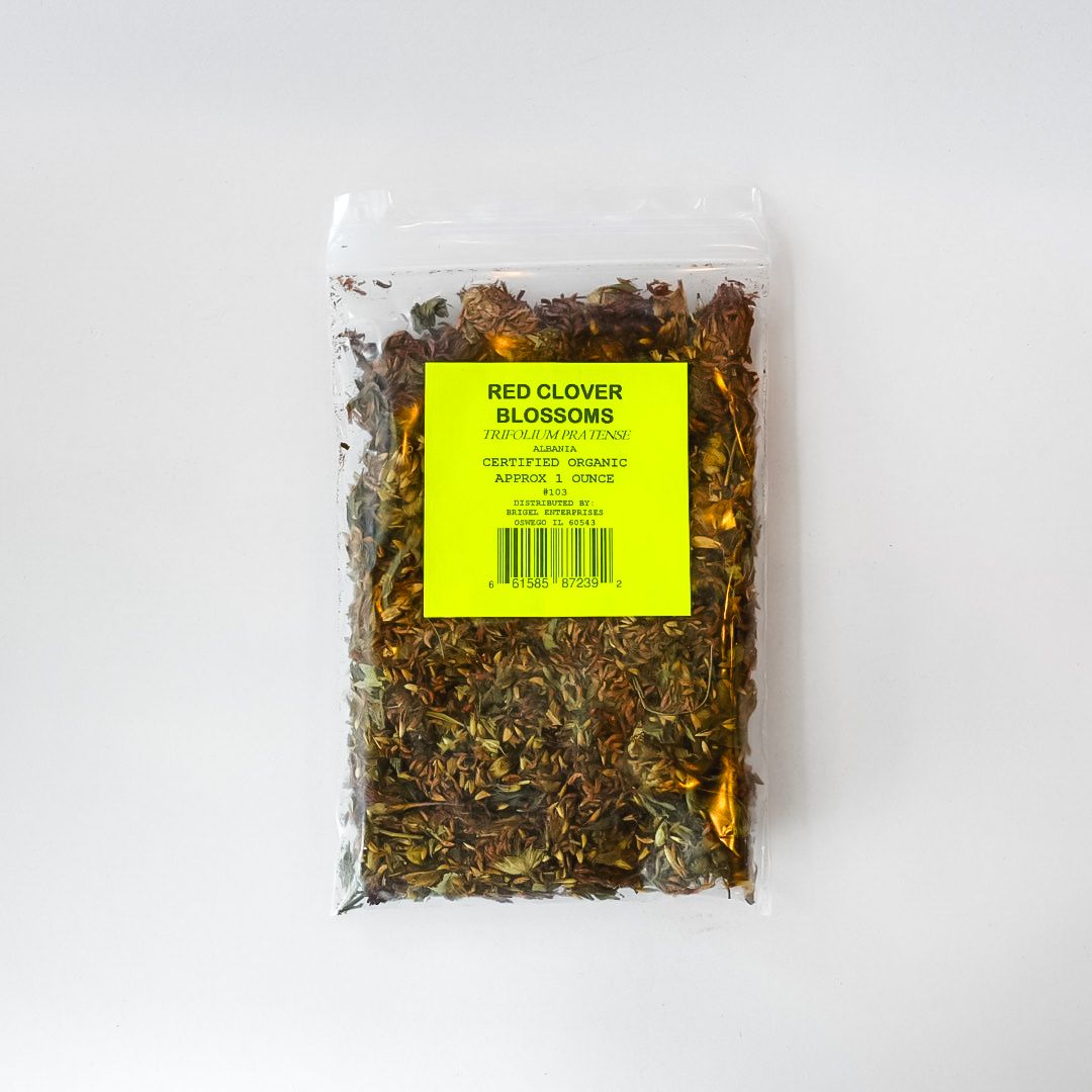 Clear plastic bag of dried red clover with a bright yellow label and barcode.