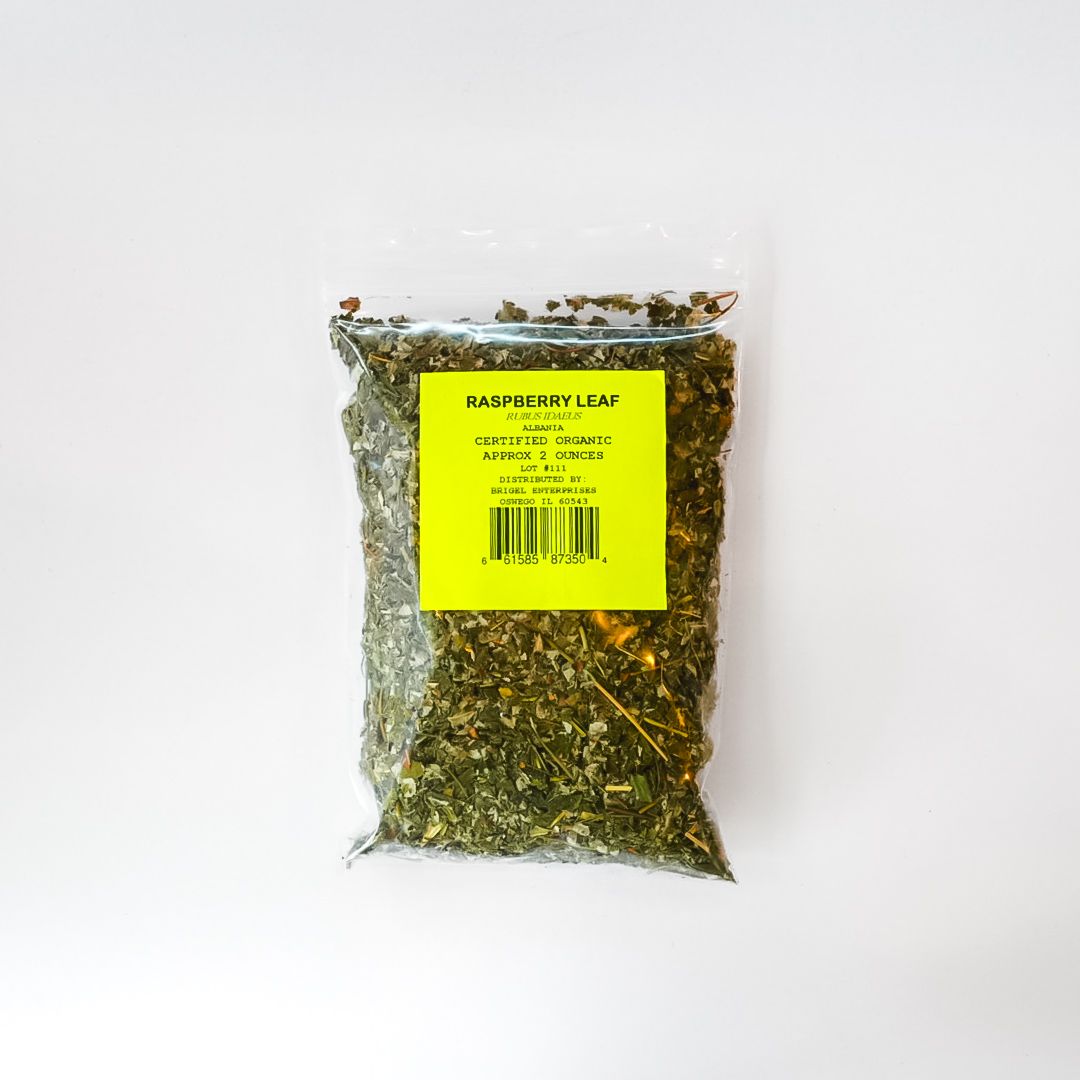 Clear plastic bag of dried green herbs with a bright yellow label on a white background