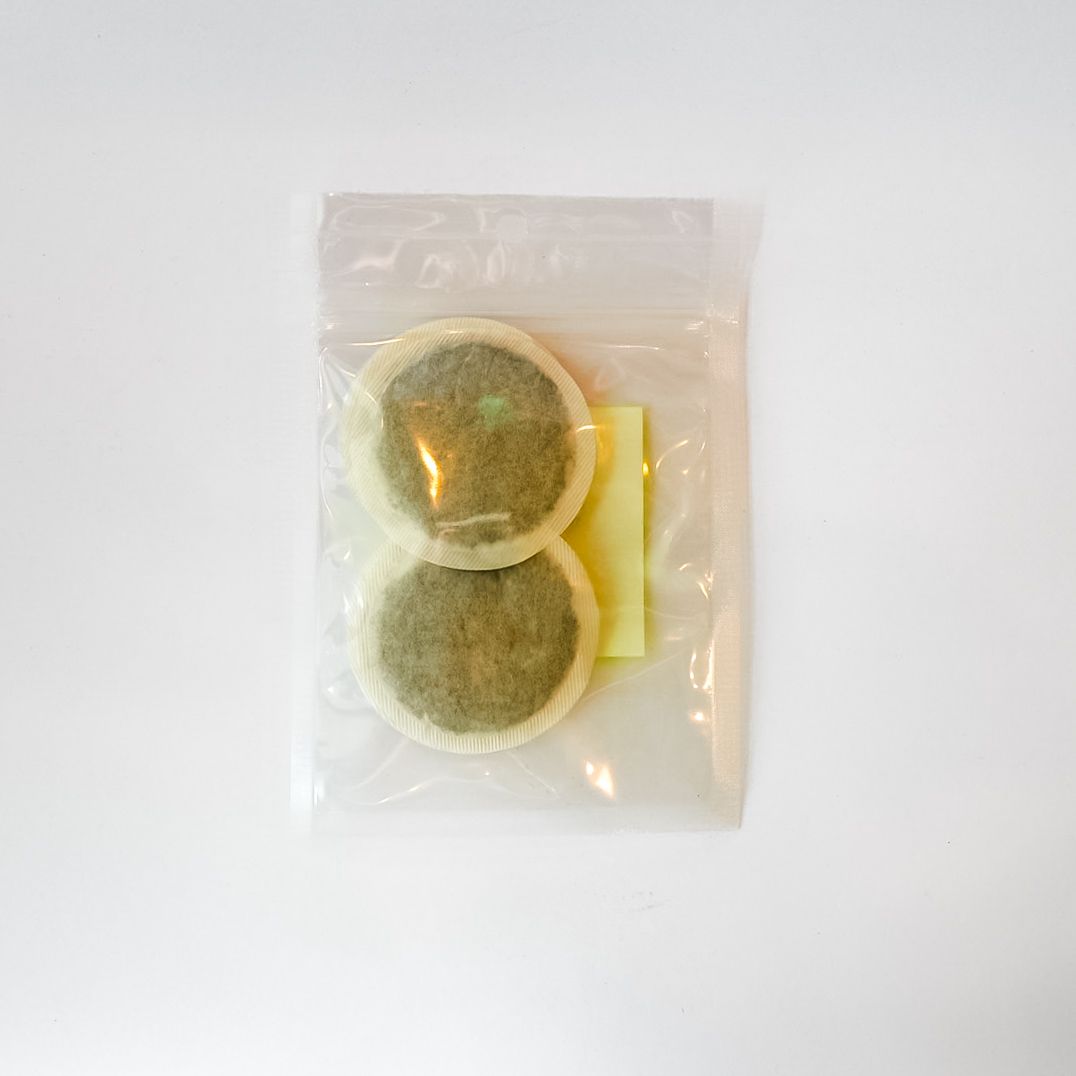Clear plastic bag holding a neon yellow-labeled item on a white background