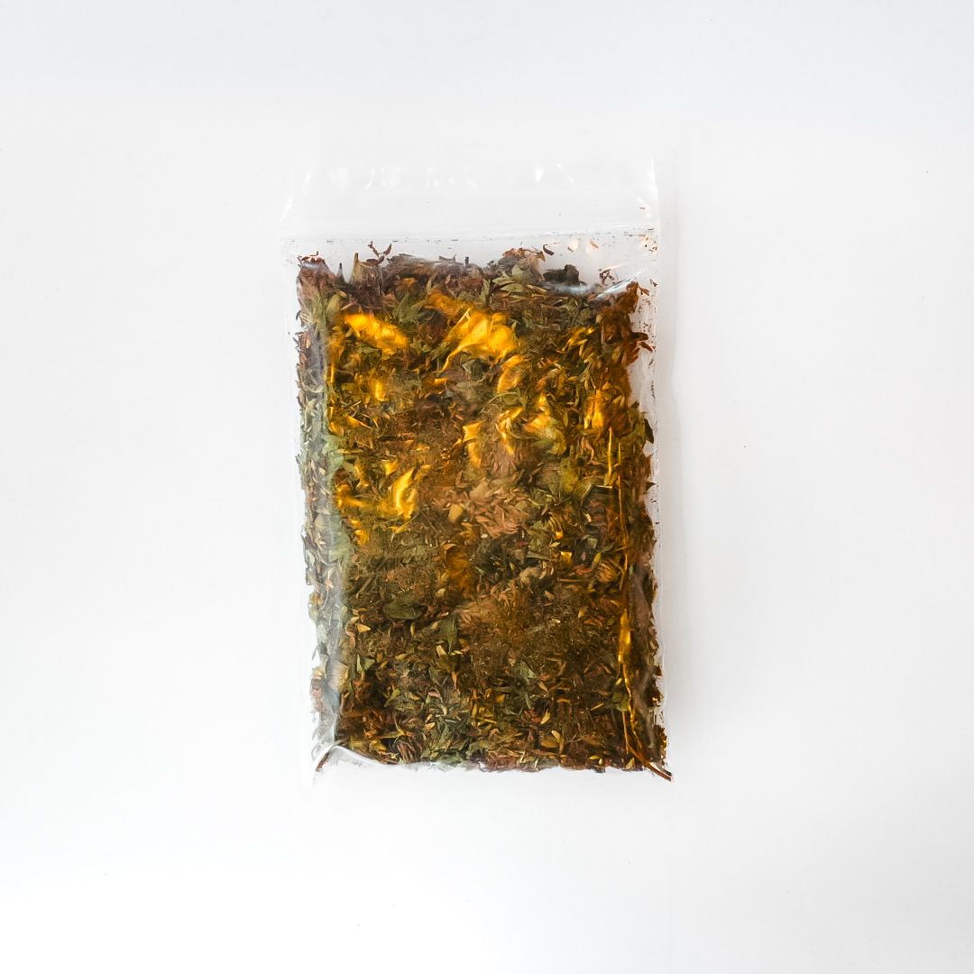 Clear plastic bag of dried red clover with a bright yellow label and barcode.