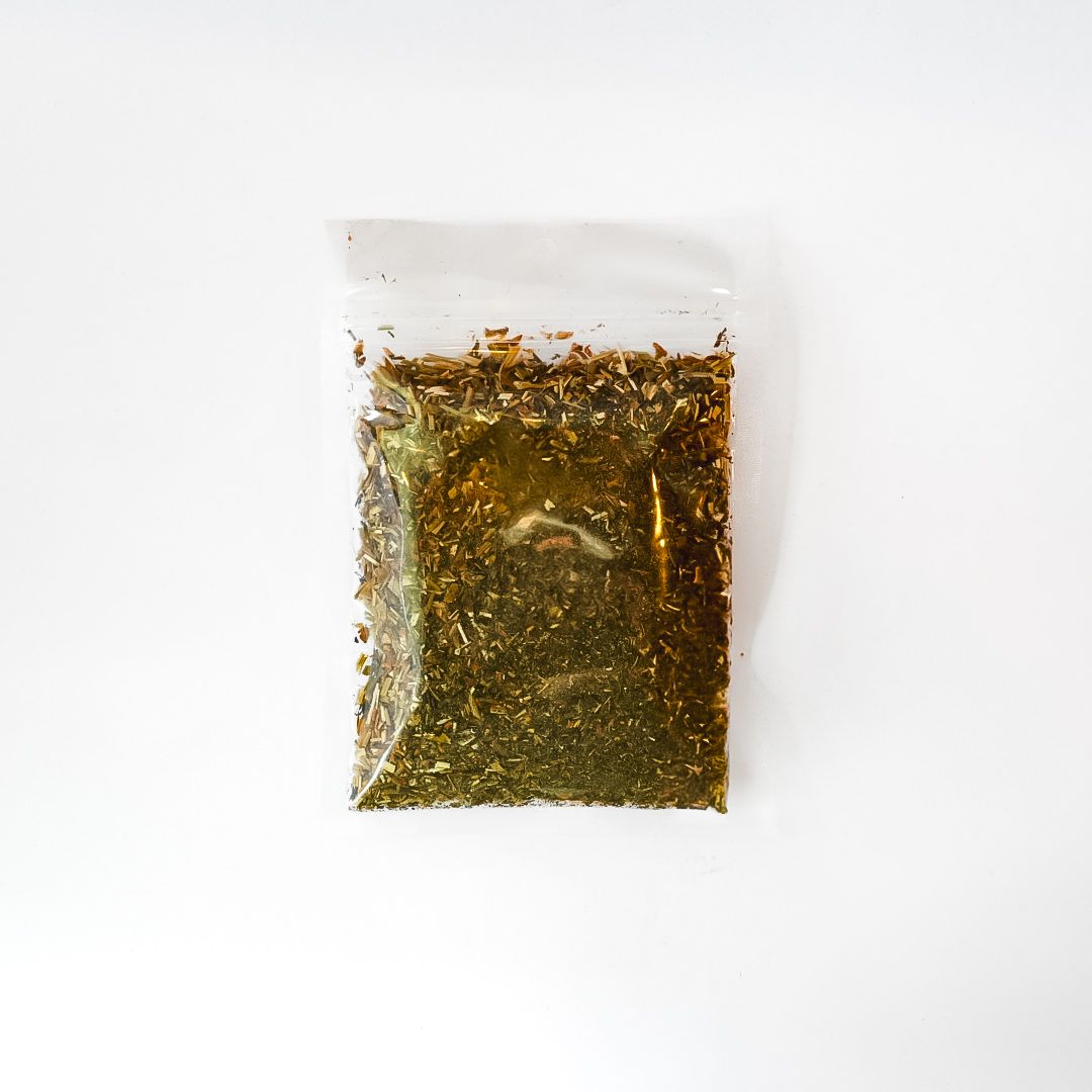 Clear plastic bag of dried herbs with a bright yellow label on a white background