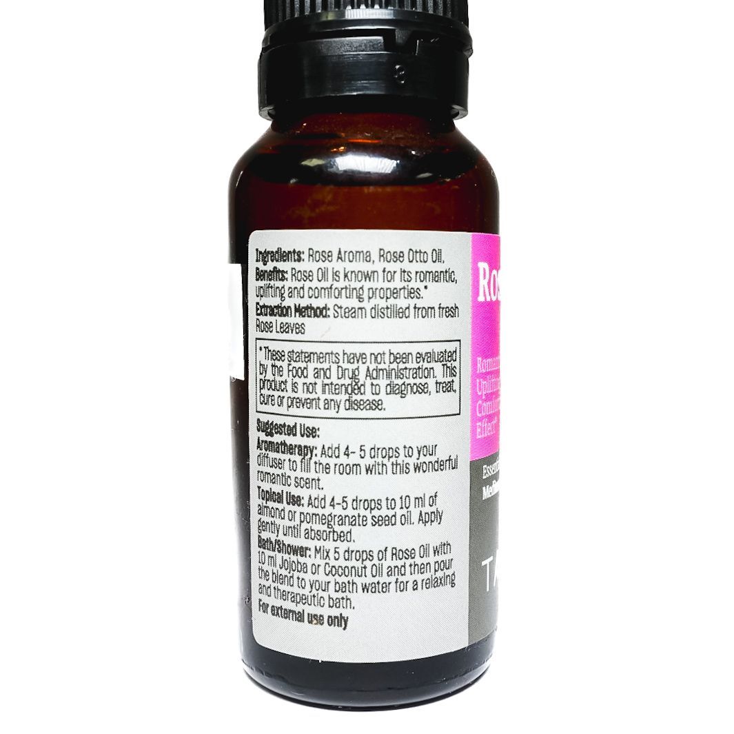 Small bottle of Talya rose oil with a black cap and pink label on a white background