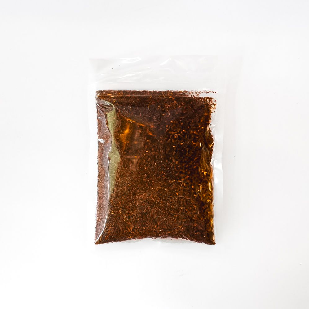 A clear plastic bag of rooibos tea with a bright yellow label on a white background.