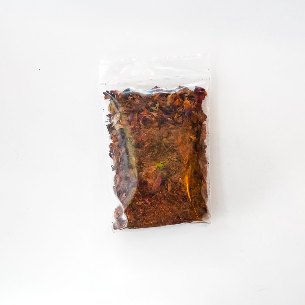 Clear bag of dried rose buds with a bright green label on a white background