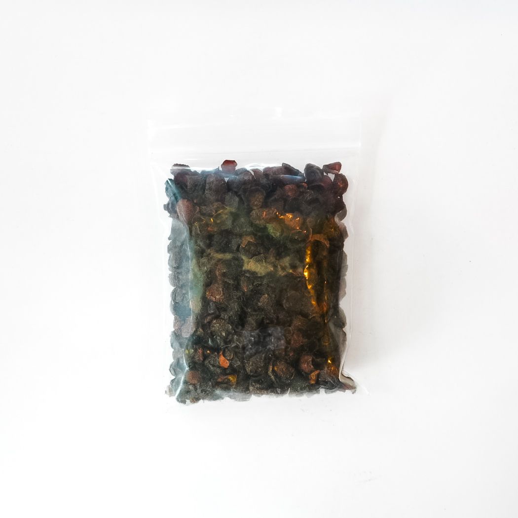 Clear plastic bag of dried rosehips with a bright yellow label on a white background