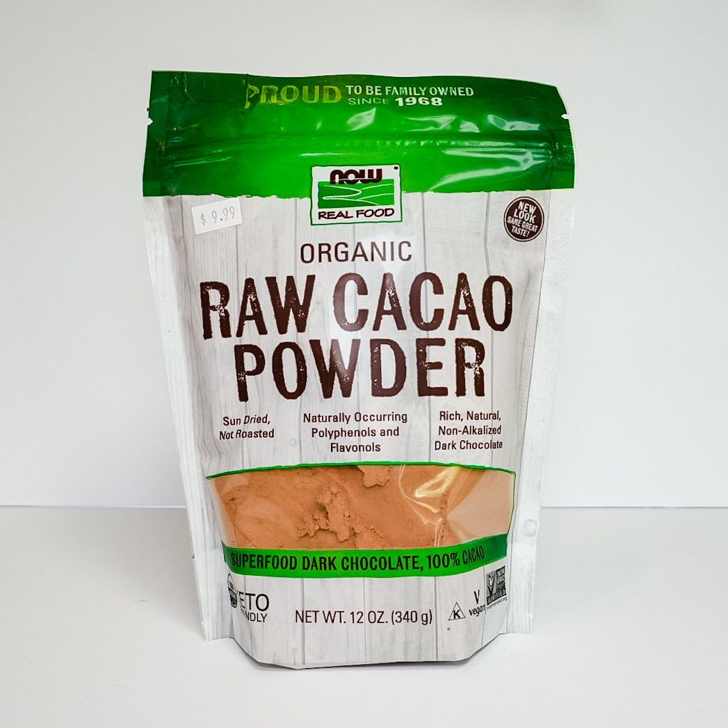 Organic raw cacao powder bag with green and white packaging on a plain white background