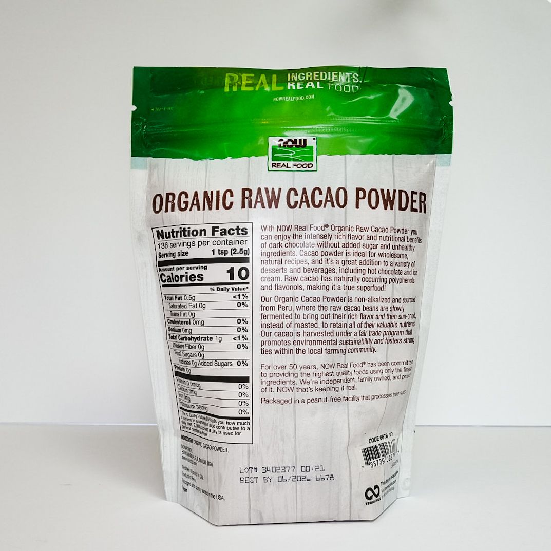 Organic raw cacao powder bag with green and white packaging on a plain white background