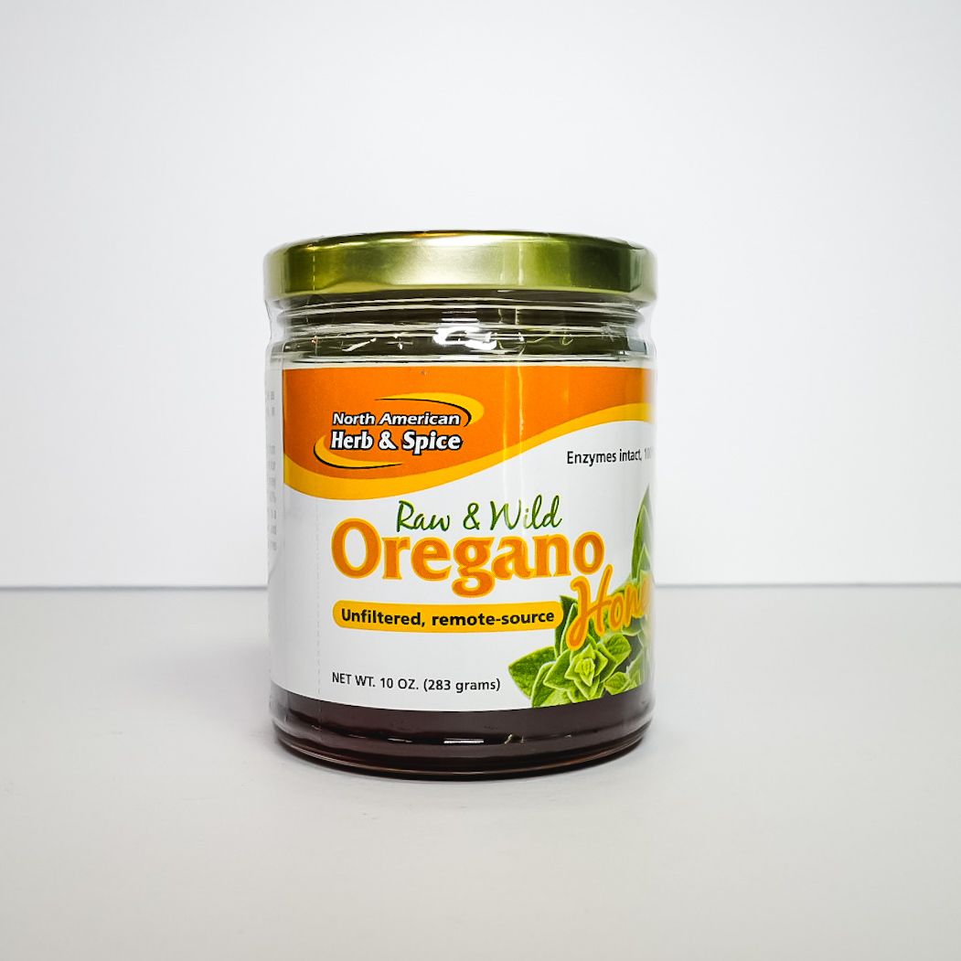 Glass jar of oregano seasoning with green lid and orange label on a white background