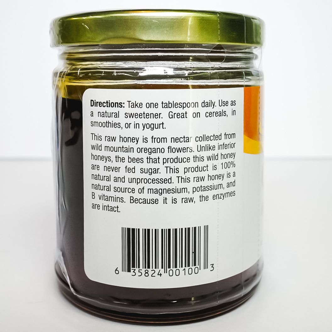 Glass jar of oregano seasoning with green lid and orange label on white background