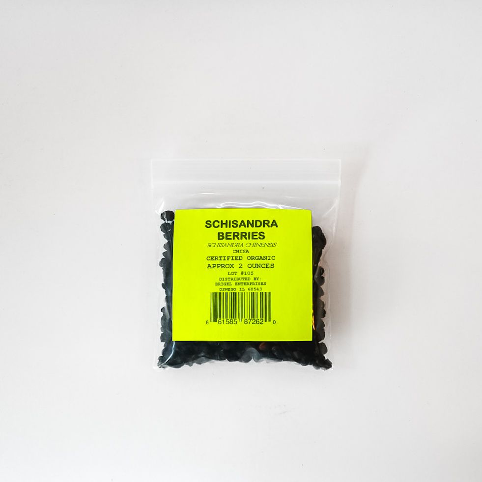 Clear plastic bag of dried schisandra berries with a bright yellow label on a white background