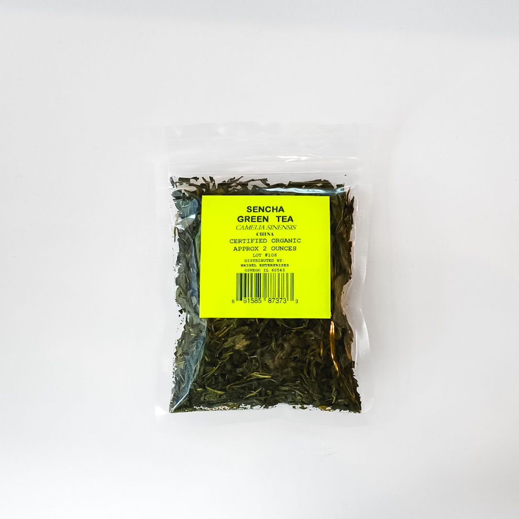 Clear plastic bag of dried tea leaves with a bright yellow label and barcode on a white background