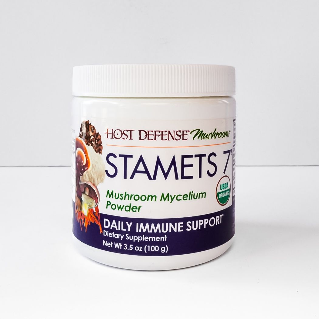 White jar of Host Defense Stamets 7 mushroom mycelium powder with purple label on a white surface