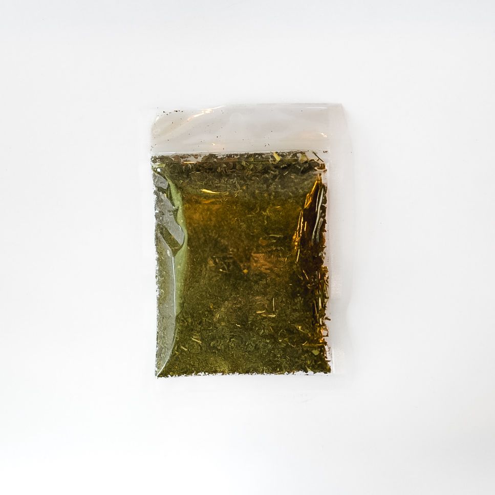 Clear plastic pouch of dried spearmint leaves with a bright yellow label on a white background