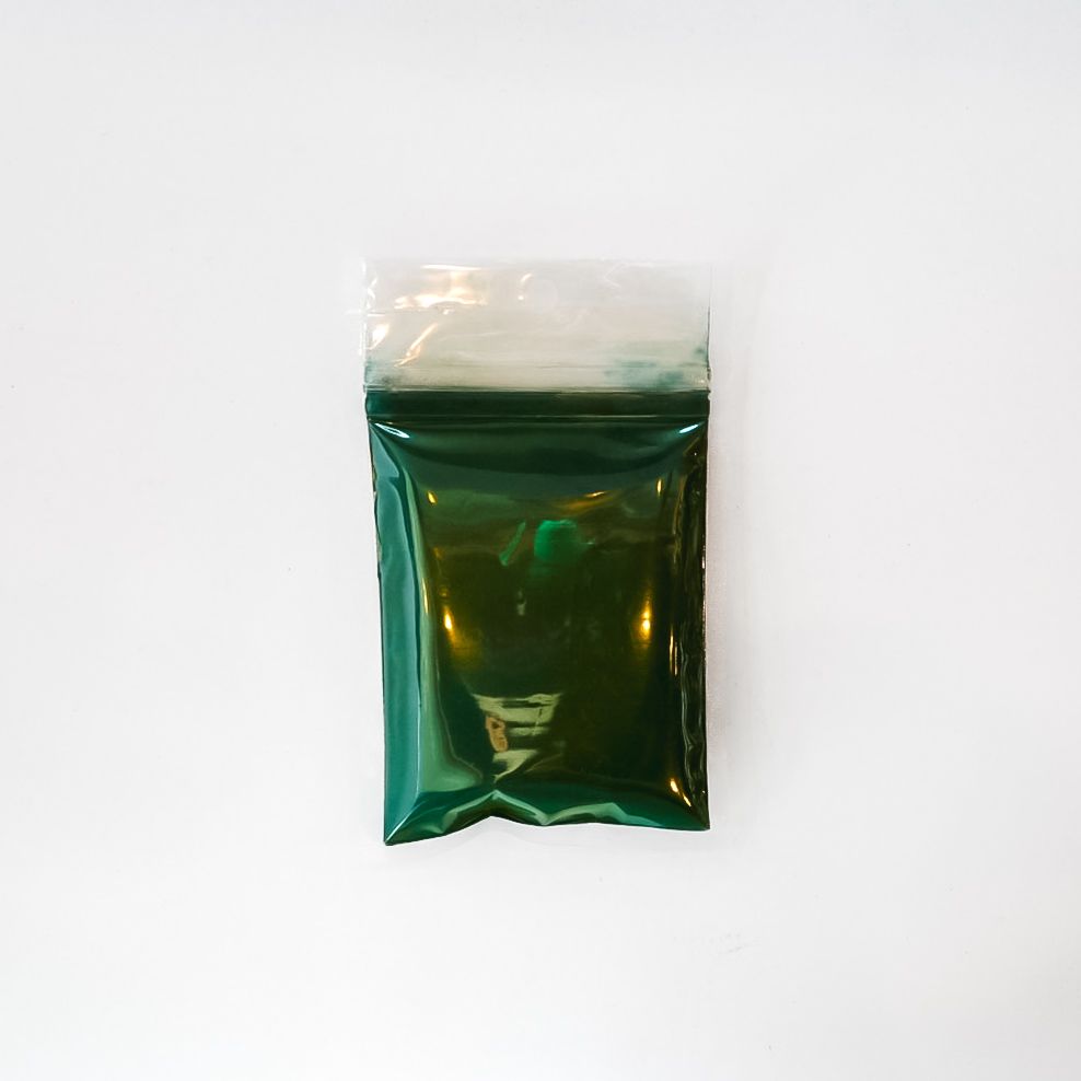 Spirulina powder packet with bright yellow label on a white background