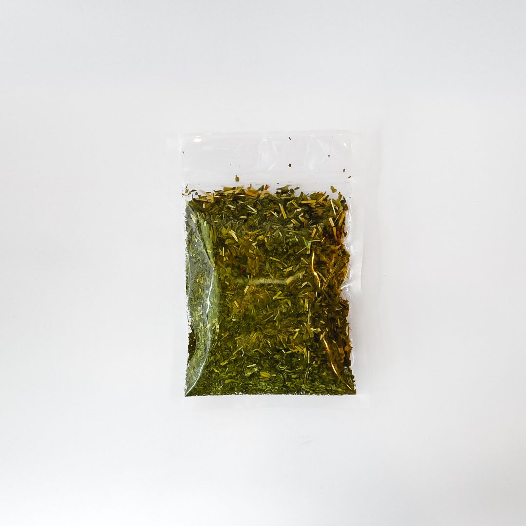 Clear bag of dried herbs with a bright yellow label on a white background