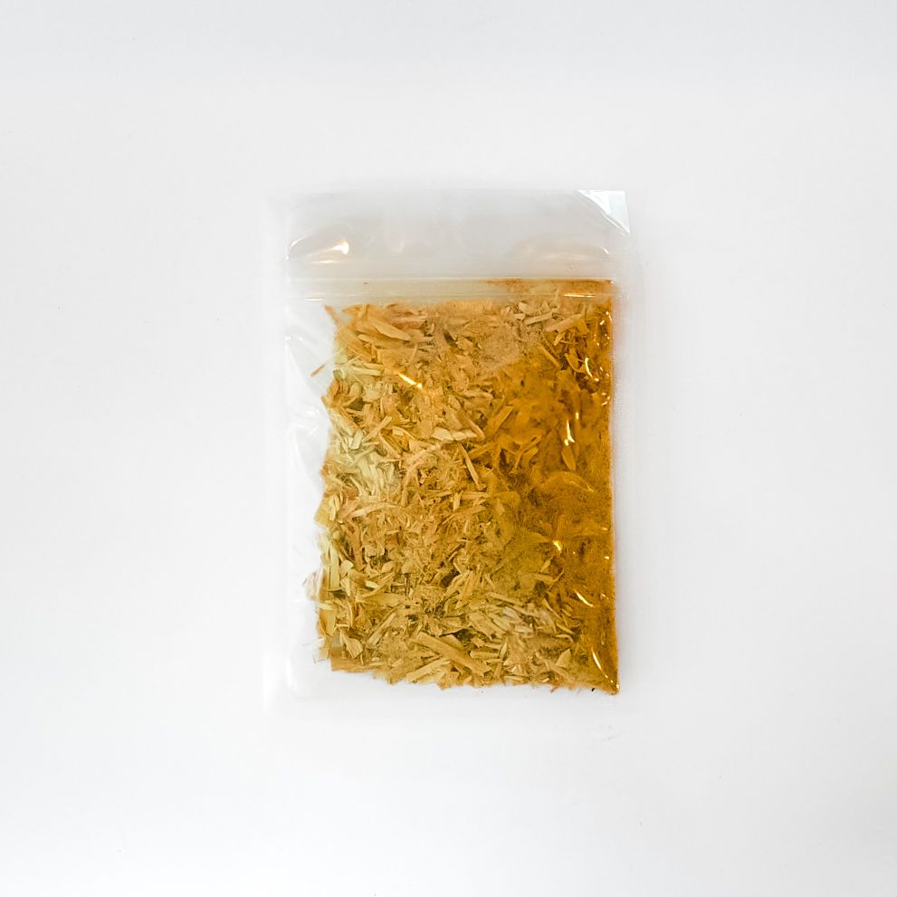 Clear plastic bag of dried leaves with a bright yellow label on a white background