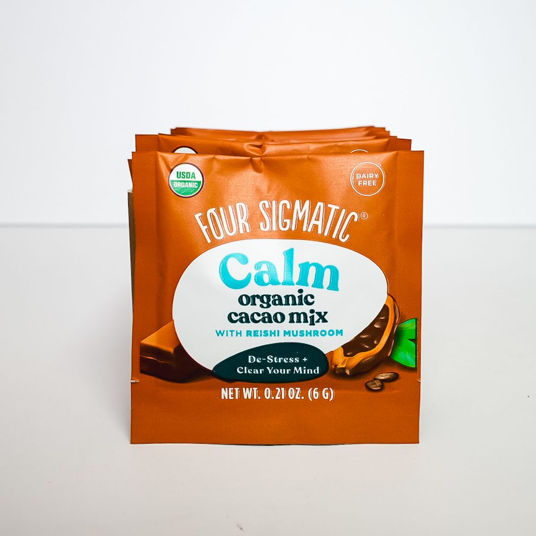 Orange bag of Calm organic cacao mix with teal and white label on a plain background