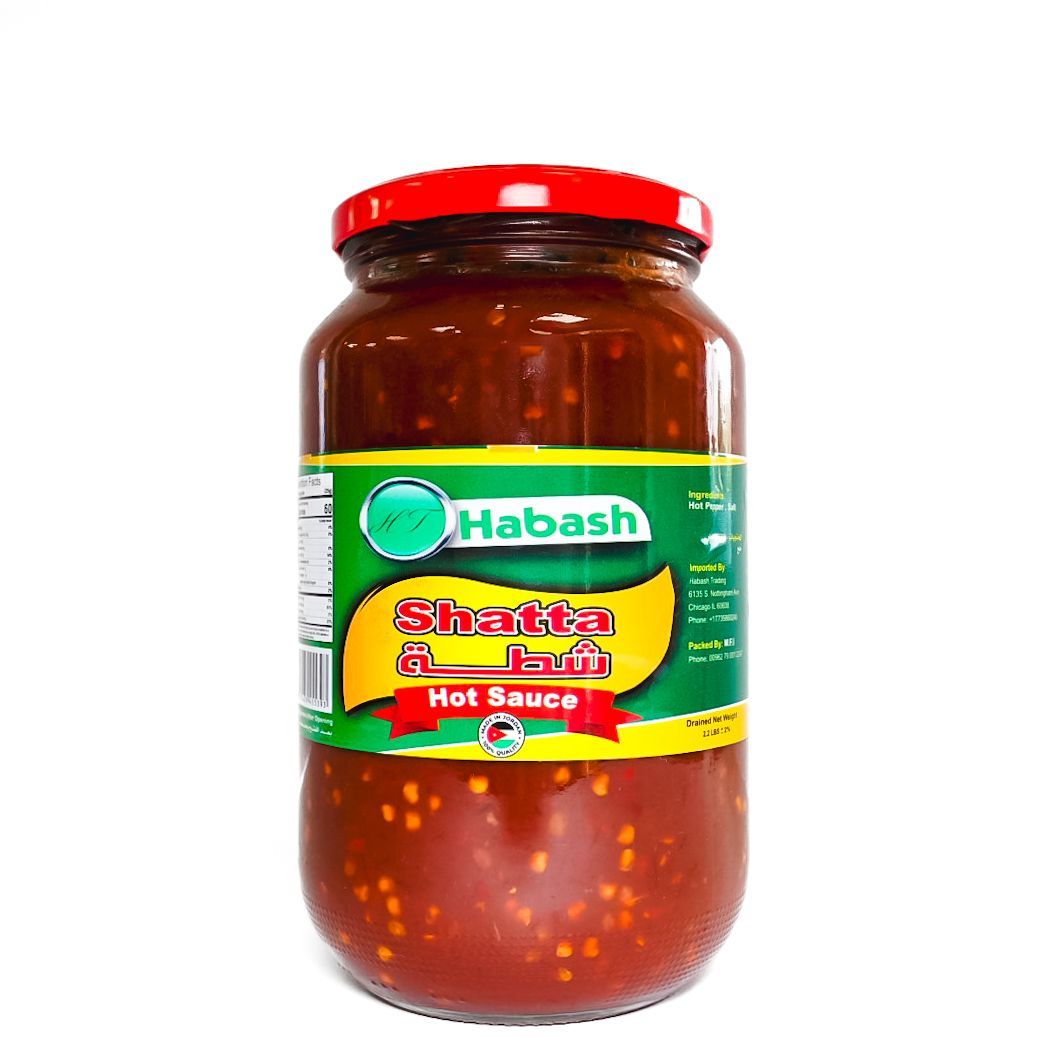 Jar of Habash hot sauce with a green label and red lid on a white background