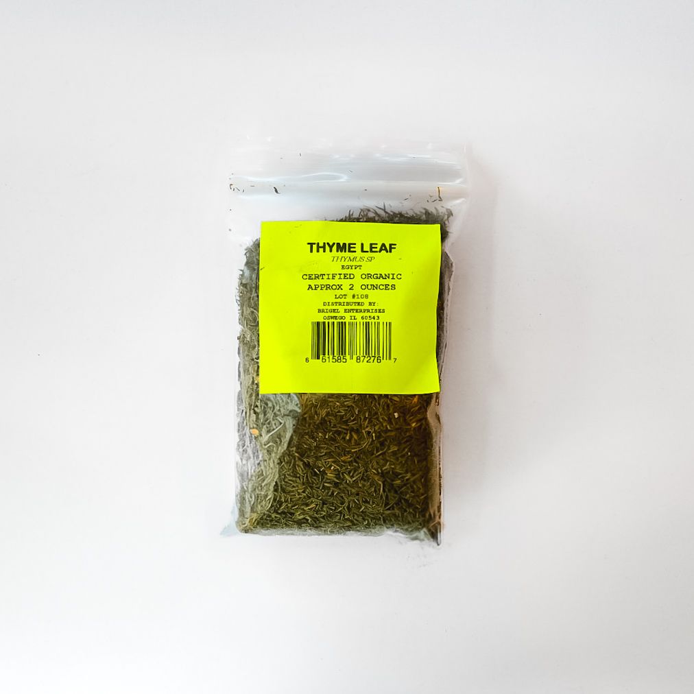 Clear bag of dried thyme leaves with a bright yellow label on a white background