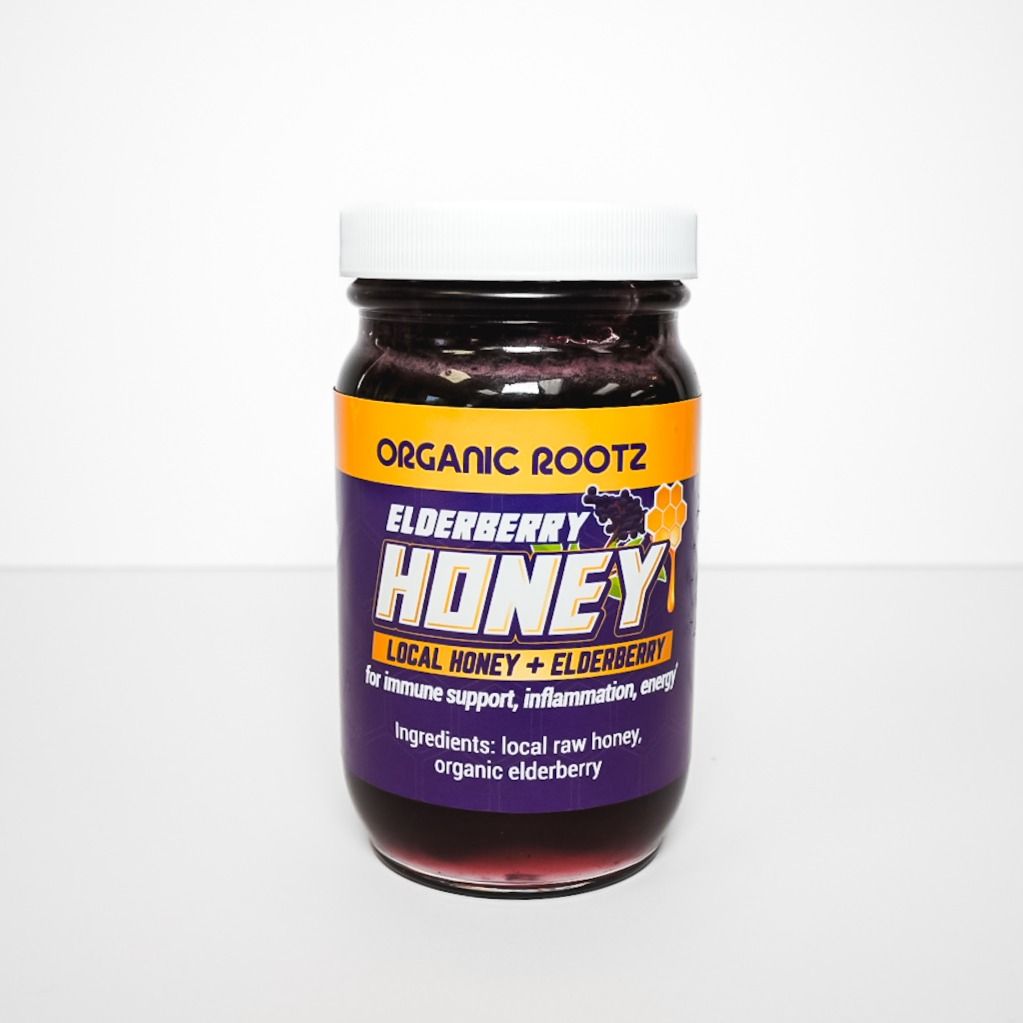 Purple jar of Organic Roots BlackBerry Honey with orange label and white lid on a light background