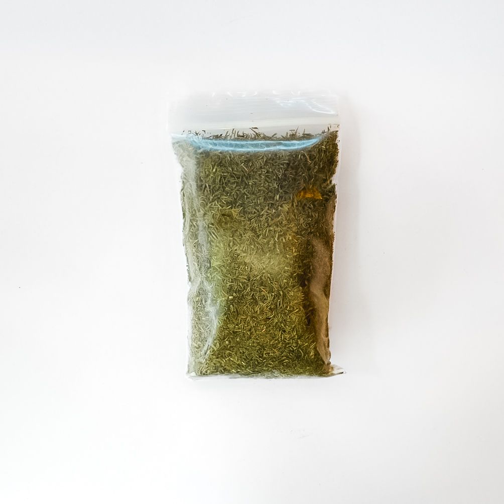 Clear bag of dried thyme leaves with a bright yellow label on a white background