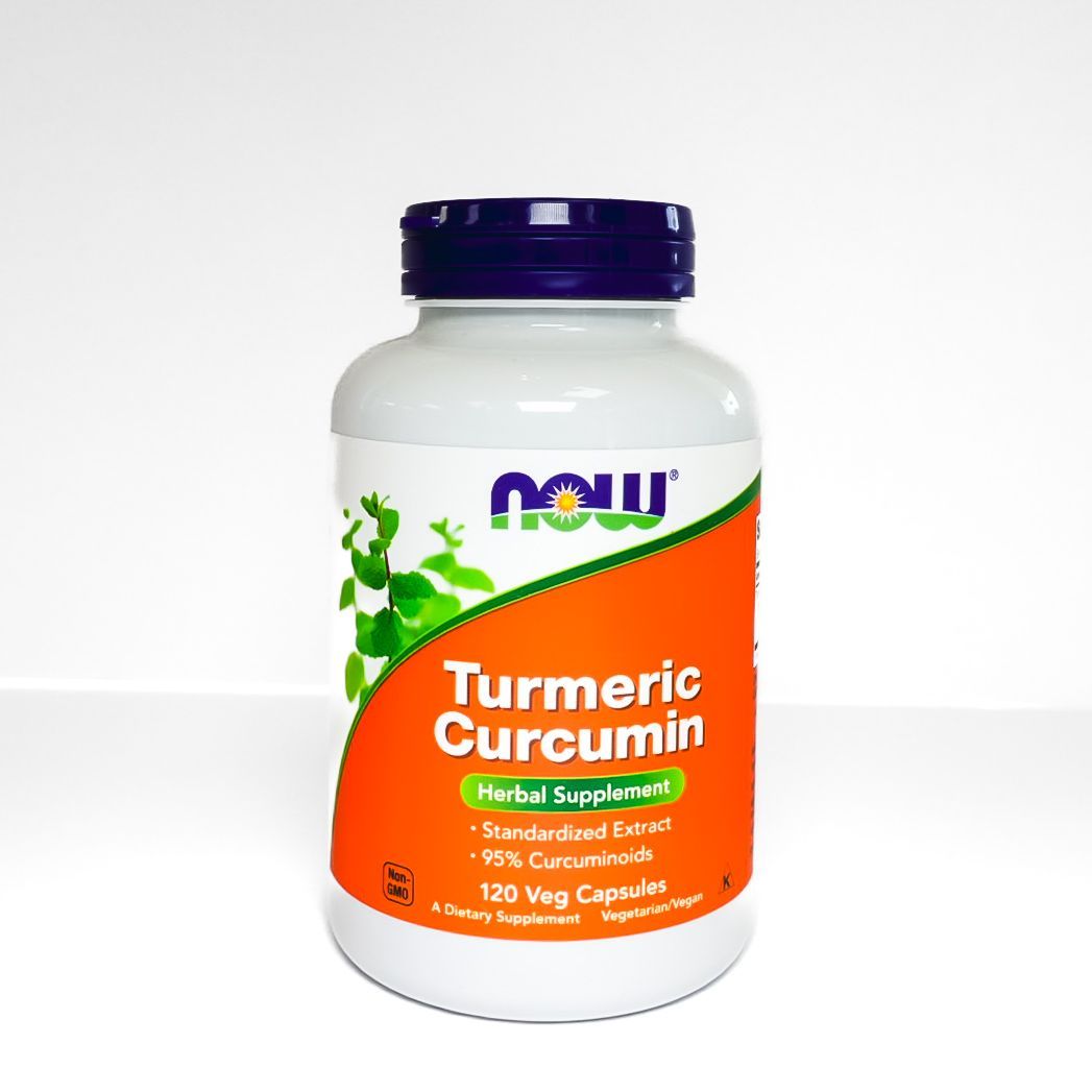NOW Turmeric Curcumin supplement bottle with orange label and purple cap on white background