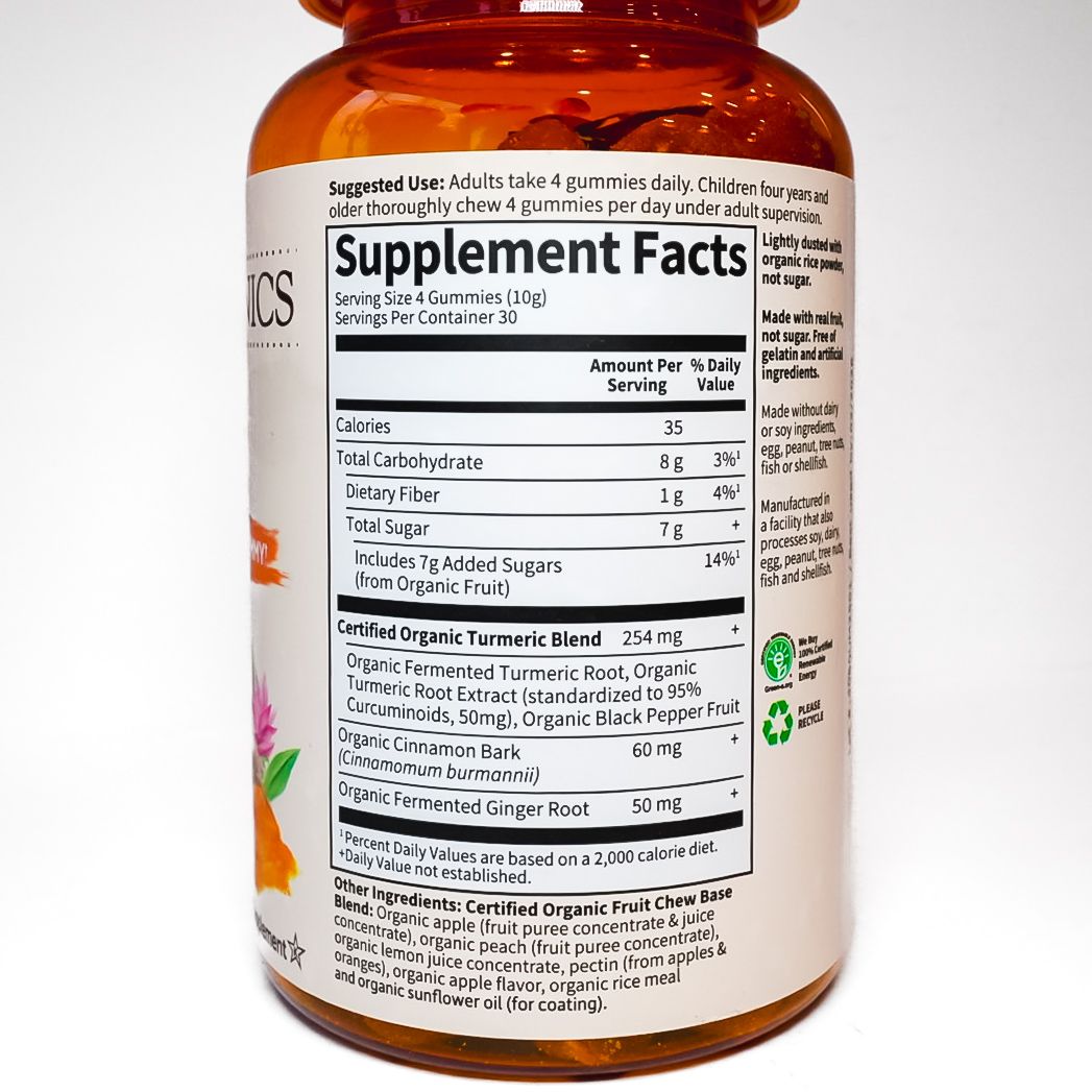 Orange bottle of turmeric supplement with white label and orange cap on a white background