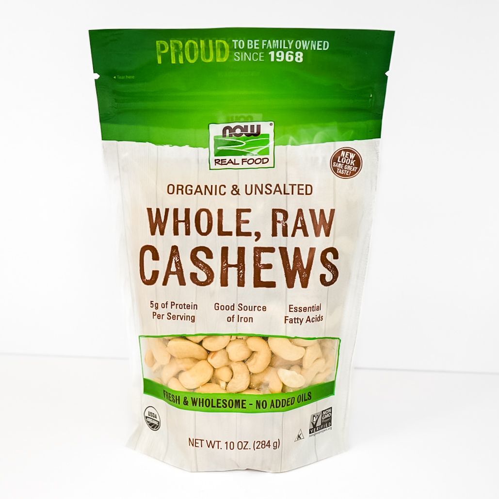 Green and white bag of organic raw whole cashews, front label facing forward