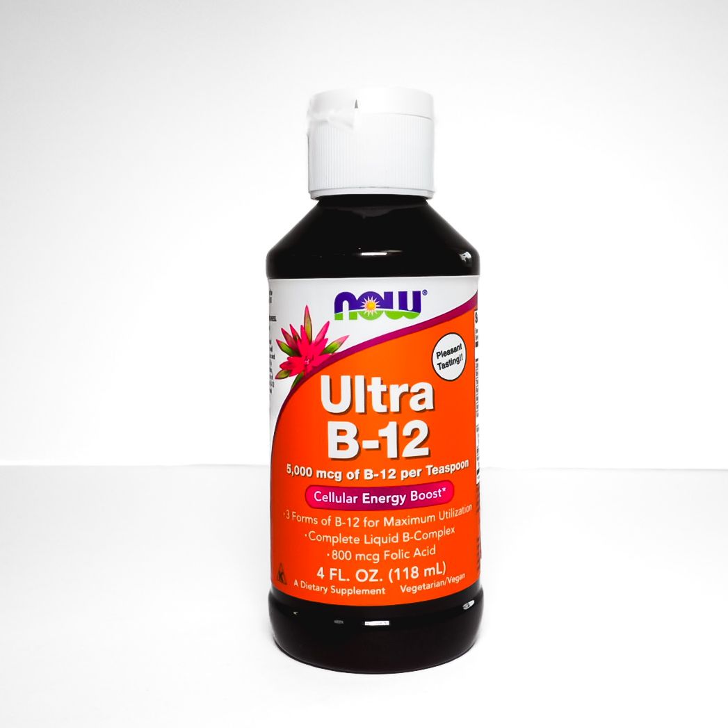 Bottle of NOW Ultra B-12 liquid supplement with orange label and black cap on white background