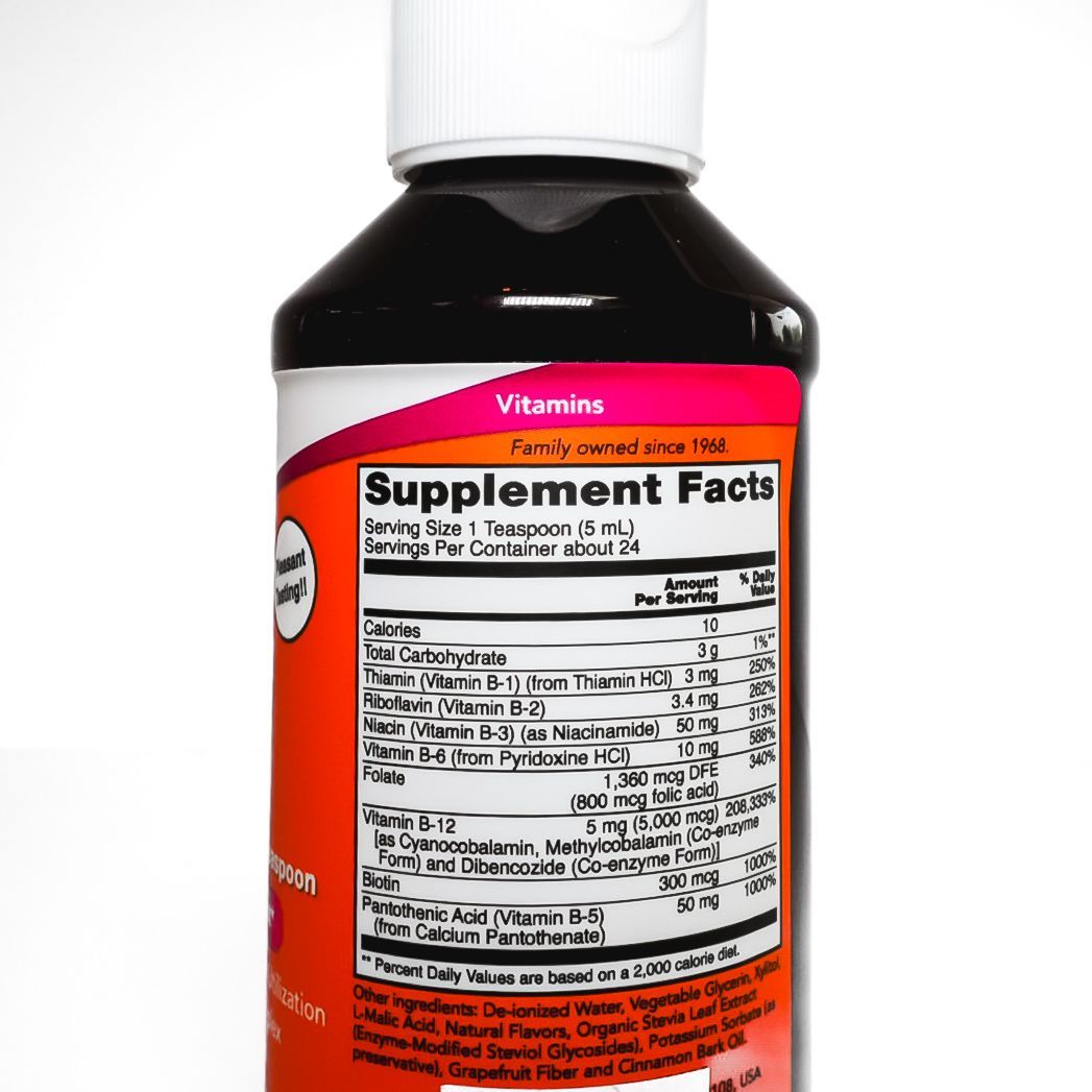 Bottle of NOW Ultra B-12 liquid supplement with orange label and black cap on white background