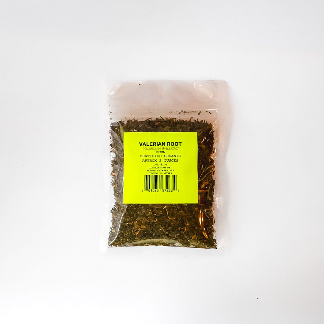 Clear plastic bag of dried herbs or tea with a bright yellow label, centered on a white background