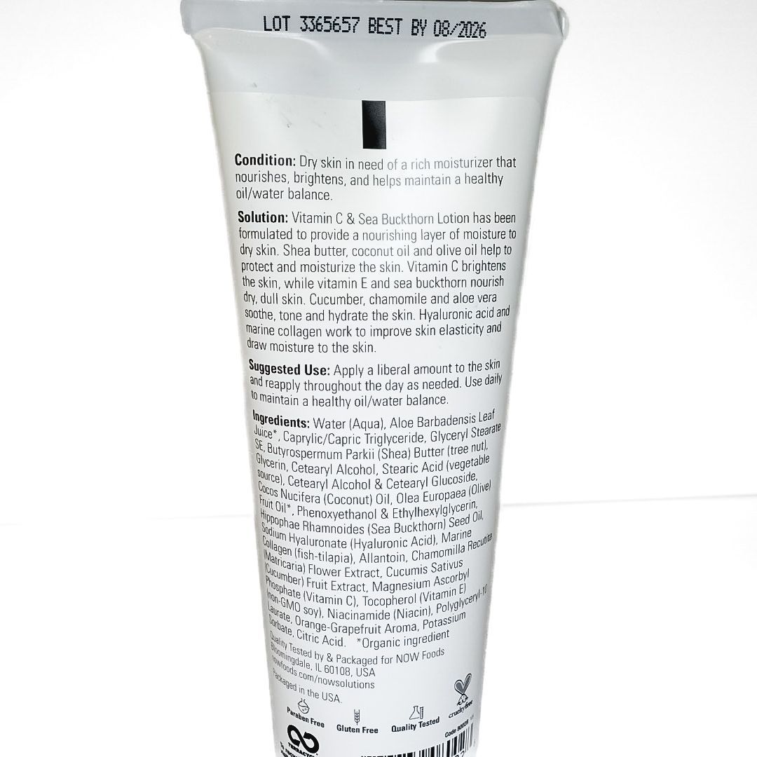 White tube of orange-scented skincare lotion with orange slices and green leaves on the label