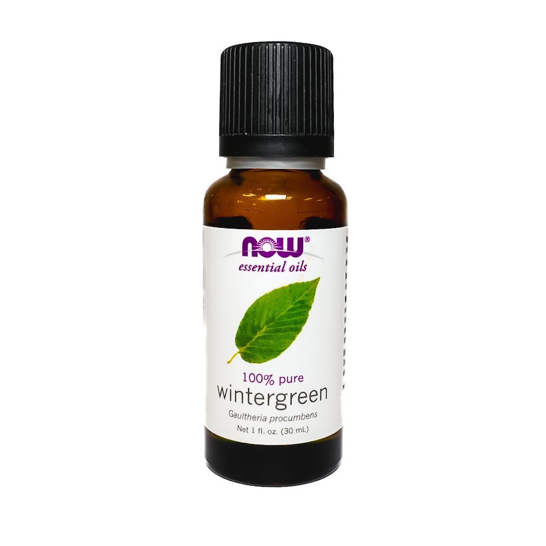Small amber bottle of NOW Wintergreen essential oil with black cap and green leaf label on white background