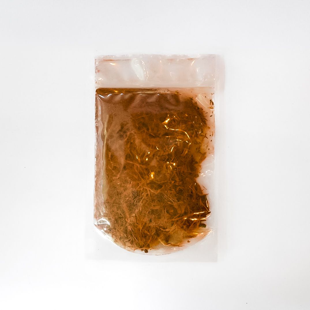 Clear bag of bark chips with a bright yellow label on a white background